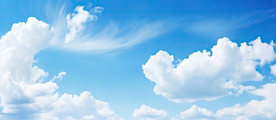 Poster - Serene summer sky with bright blue hues and soft white clouds, ideal for copy space and tranquil backgrounds, with clouds in upper third.