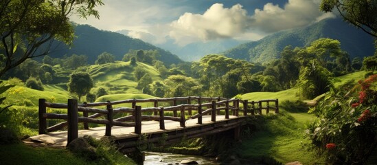 Aufkleber - Serene landscape view featuring a rustic wooden bridge crossing a gentle stream, surrounded by lush green hills and trees under soft skies.