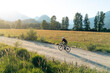© Cavan Images - Solo cyclist biking a gravel road at sunrise in the countryside.