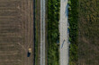 © Cavan Images - Drone shot cyclist on a gravel road in a sunlit rural landscape