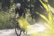 © Cavan Images - Solo biker on a dirt trail in a forest, exploring fitness and nature.