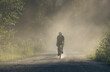 © Cavan Images - Mountain biker on a dirt road during golden hour in a calm valley.