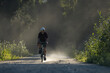 © Cavan Images - Cyclist riding a dirt trail in a peaceful rural setting with nature.