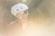 © Cavan Images - Male cyclist in golden light, wearing protective gear and earbuds