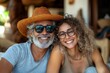 © c80 - Smiling older couple enjoying a sunny day outdoors wearing stylish hats and glasses in a relaxed setting