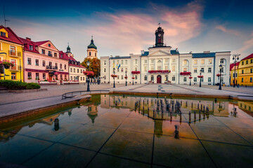 Wall Mural - Captivating morning cityscape of Plock town, Masovian Voivodeship. Calm summer sunrise on Market Square with Town Hall reflected in the fountain, Poland, Europe. Travel the world.