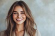 © KP - A smiling woman with long hair poses confidently against a soft, neutral background, radiating warmth and approachability.