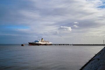 Wall Mural - Luxury Cruise Ship Docked at Scenic Waterfront On A Clear Day