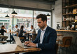© OlehStock - Businessman working on laptop in coffee shop