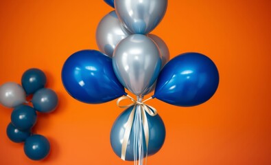 Wall Mural - Vibrant orange background, shiny metallic blue balloons, reflective silver balloons, cluster of balloons, high contrast, studio lighting, professional product photography, festive atmosphere, celebrat