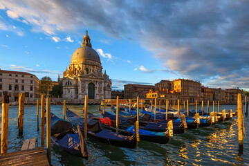 Wall Mural - sunrise view of canal grande with venice gondola and basilica di santa maria della salute in venice,
