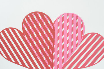 Wall Mural - layered striped heart shapes machine-cut from red and pink crafting paper and arranged on blank paper