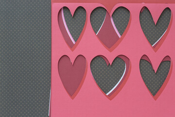 Wall Mural - stencil with heart pattern machine-cut from a variety of pink and red crafting papers and arranged in a rough pile on brown paper with dots