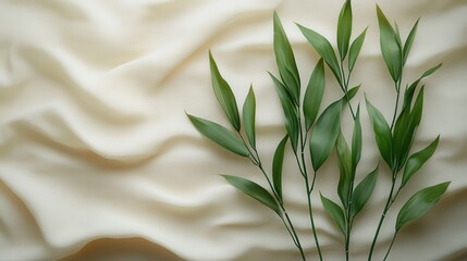 Wall Mural - Green leaves elegantly arranged on a soft, textured fabric background, creating a serene atmosphere