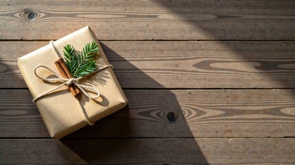 Aufkleber - A thoughtfully wrapped present rests on a rustic wooden surface, bathed in warm sunlight; a sprig of evergreen and cinnamon sticks add a touch of natural elegance.
