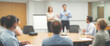 © Pathi - Blurred background of a confident speaker explaining project strategies during a team presentation in a modern office, wide