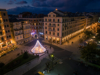 Wall Mural - Aerial view of the Liston, in Corfu Town, Greece, illuminated for Christmas. The square is decorated with festive lights and a Christmas tree.