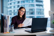 © Home-stock - Focused woman secretary accountant working with documents, checking financial reports at workplace in office
