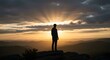 © DigiwaveCreators - Man standing on top of cliff at sunset