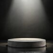 © black - Spotlight on a circular concrete pedestal in a dark room.