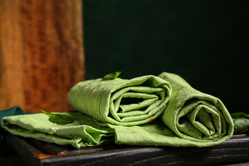 Wall Mural - Board with fresh green lavash and spinach, closeup