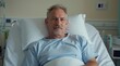 © Prasitama - Portrait of mature man sitting on bed in hospital ward
