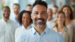 © Vilaysack - confident man smiling in front of diverse group of people, showcasing leadership and unity
