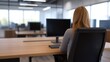 © Blackmint Studio - Modern office interior featuring a woman working at a computer in a spacious and bright workspace with large windows and minimalist design elements
