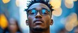 © ngstock - Young man with stylish glasses poses confidently in a blurred urban background showcasing vibrant city life