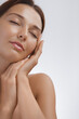 © Buyanskyy Production - Close-up of a young Caucasian woman with flawless, glowing skin gently touching her face with closed eyes, symbolizing relaxation and self-care. Ideal for skincare, wellness, and beauty promotions.