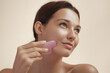 © Buyanskyy Production - Portrait of a young Caucasian woman gently massaging her face with a pink gua sha stone, symbolizing self-care, beauty, and skincare. Perfect for wellness and organic beauty branding.