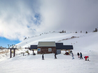 Wall Mural - Chairlift unloading point at the top of the ski resort with thick clouds (Kawaba, Gunma, Japan)