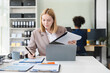 © NINENII - Businesswomen hand working with tablet and laptop computer with documents on office desk.