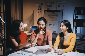 Canvas Print - Business people working late at laptop in highrise office