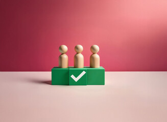 Leinwandbilder - Three wooden figurines stand on a green block with a checkmark, against a grainy, textured pink backdrop.  The image has a minimalist, conceptual feel.