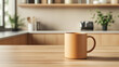 © Dhea Avila - Blank matte brown coffee cup mockup on wooden kitchen table, on minimalist kitchen background.