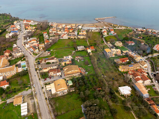 Wall Mural - Aerial view of a coastal town with buildings, roads, and green spaces.