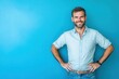 © Alexei - A man in a blue shirt stands with hands on hips, smiling
