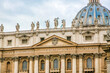© vip-photoworld - A large building St. Peter's Church of Vatican in Italy with a blue dome and a cross on top. The building has a lot of statues on it