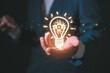 © cherdchai - A lightbulb with AI icon floating on hand showing the transfer of innovative ideas Artificial intelligence technology concept with AI