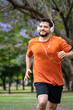 © Javier - Hombre entrenando, trotando y sonriendo en un parque urbano en un hermoso día soleado. Hombre feliz corriendo
