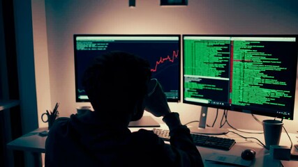 Leinwandbilder - Person working with programming code on dual monitors in a dimly lit workspace