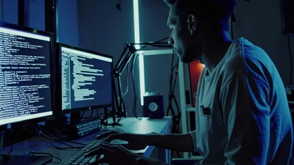 Fototapete - Tech enthusiast codes intensely in a dimly lit workspace surrounded by multiple monitors