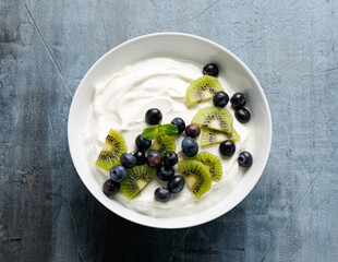 Wall Mural - Greek yogurt with fresh blueberries and kiwi. Probiotic healthy food breakfast