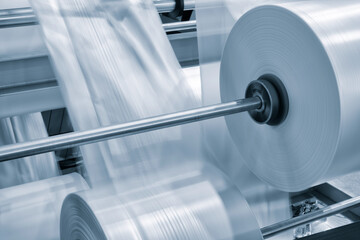 Poster - Automatic polyethylene plastic bag production machine with lighting effect. Close-up of the roller of the plastic bag production machine in the light blue scene. product packaging concept