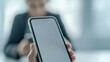 © เด็กชาย นุ่มนิ่ม - spam call phone security concept. A person holding a smartphone with a blank screen, focused on mobile interaction in a modern environment.