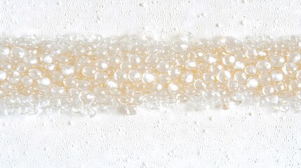 Wall Mural - A row of transparent water beads placed meticulously on a smooth white backdrop, each one reflecting soft light and showing a high level of detail and precision