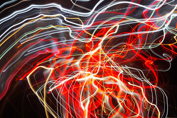 Wall Mural - Abstract blurred colorful light effect on a black background. Long exposure photo of moving camera.