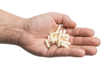 Male hand holding a pile of white medicine capsules in a palm, antibiotic pills, vitamins, or painkillers, isolated on transparent background. Healthcare and treatment concept