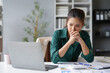 © Crystal - Stressed businesswoman looking worriedly at laptop while working in office